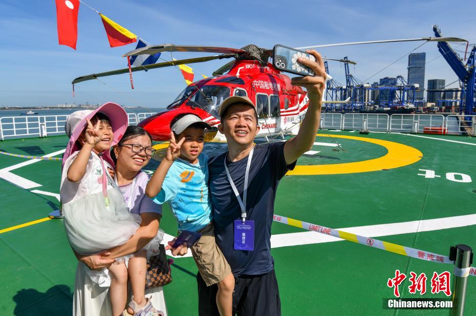 中新社记者 骆云飞 摄 6月2日，完成中国第41次南极考察任务的“雪龙2”号极地科学考察破冰船，停靠在海南省海口市秀英港码头，开启为期5天的公众开放日活动。公众可近距离参观实验室、驾驶室以及飞行平台等多个特色区域。“雪龙2”号是中国首艘自主建造的极地科学考察破冰船。图为民众在“雪龙2”号极地科学考察破冰船飞行平台自拍合影。