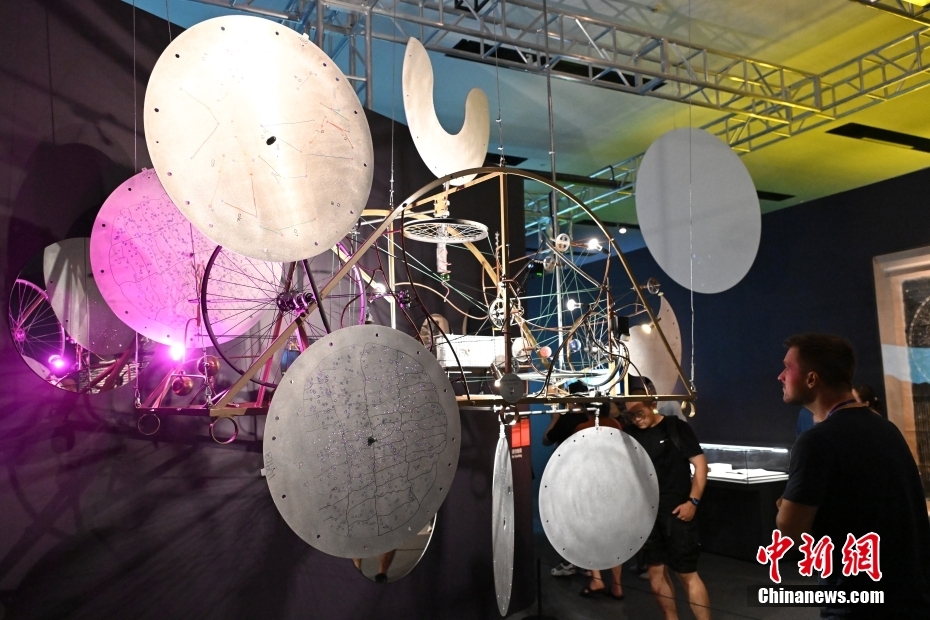 7月2日，由中国国家博物馆、瑞士驻华大使馆、瑞士洛桑联邦理工学院主办，清华大学天文系、清华大学美术学院协办的“宇宙考古：时空探索”展览在北京中国国家博物馆开展。展览分为“仪器和技术：绘制宇宙”“大数据的星空”“可持续的太空”“未来：行星之旅”四个部分，融科学探索和艺术诠释为一体，将宇宙中真实、分散、抽象的数据，通过数字装置、互动体验、动态雕塑和前瞻性设计等多种形式呈现出来。图为参观者在观看来自瑞士的动态雕塑《巡星雕塑》。 中新社记者 田雨昊 摄