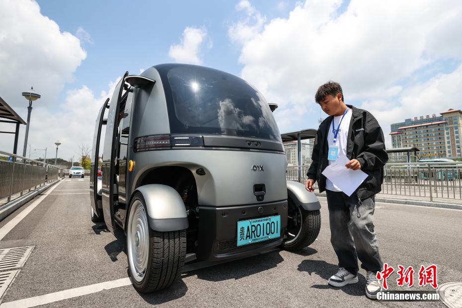 中新社记者 瞿宏伦 摄 5月4日，安全员对无人驾驶巴士进行巡检。当日，贵州首条无人驾驶公交线——“无人驾驶花溪大学城专线”在贵州省贵安新区开通运营。该专线使用的无人驾驶巴士核载6人，具备L4级自动驾驶能力，能为乘客提供3-10公里的无人接驳服务。专线主要基于公交运营模式，单向全程为5公里，通勤时长为15分钟至20分钟，5月4日至31日实行免费体验，乘客可通过扫描站牌二维码或线上预约乘坐。