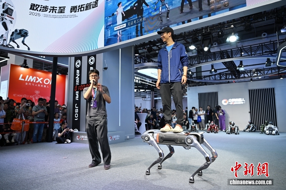 中新社记者 王紫儒 摄 8月10日正值周末，世界机器人大会人气旺。2025世界机器人大会于8月8日至12日在北京亦庄举行，主题为“让机器人更智慧，让具身体更智能”。图为观众体验机器狗的载重能力。