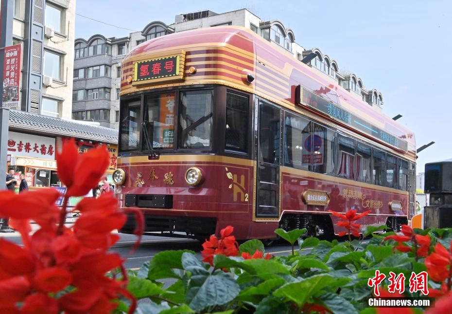 中新社记者 张瑶 摄 6月4日，氢能源文旅专列停在长春街头。该专列由中车长客研制，以历史文化街区新民大街建筑群为设计灵感，车内君子兰花海主题内饰与复古留声机相映成趣。列车采用三级安全防护氢能系统，单次加氢续航320公里。