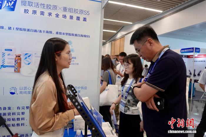 图为参展商向观众介绍产品。中新社记者 刘子琳 摄