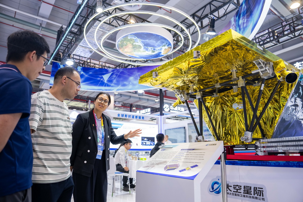 9月24日，在株洲国际会展中心，工作人员（左三）在介绍一台对地观测卫星。 9月24日，第四届北斗规模应用国际峰会在湖南株洲开幕，本届峰会以“同世界·共北斗——智联时空”为主题，除开幕式外，还设置1场高端主旨演讲、5场主题论坛、6场学术交流、1个场景示范展等活动，展示北斗规模应用与经济社会的深度融合。新华社记者 陈思汗 摄