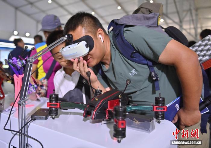 图为参观者用VR眼镜观看穿越无人机画面。 中新社记者 张瑶 摄