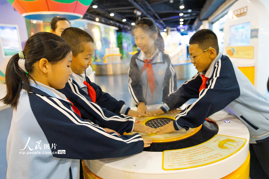 2025年9月5日，新疆乌鲁木齐市第73小学组织学生们来到新疆科技馆参观，学生们正在体验发烟装置。孙振嵩摄（人民图片网）