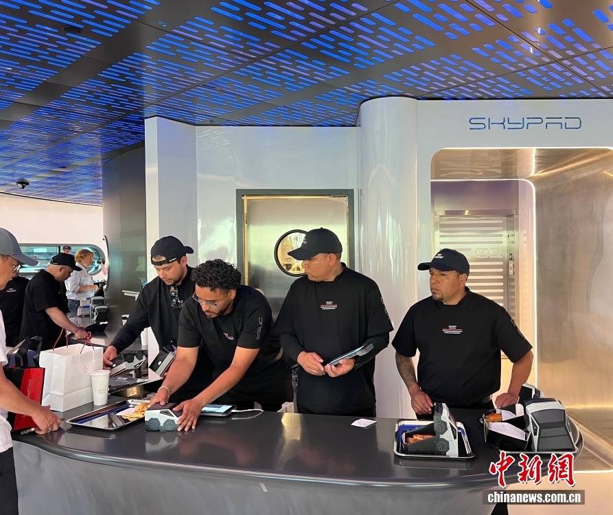 当地时间7月21日下午，美国人工智能巨头特斯拉公司的首家超级充电站餐厅在洛杉矶正式向公众开放，无特斯拉车辆也可访问。图为特斯拉首家超级充电站餐厅内，服务员给顾客准备餐食，食盒是特斯拉电动车造型。 中新社记者 张朔 摄