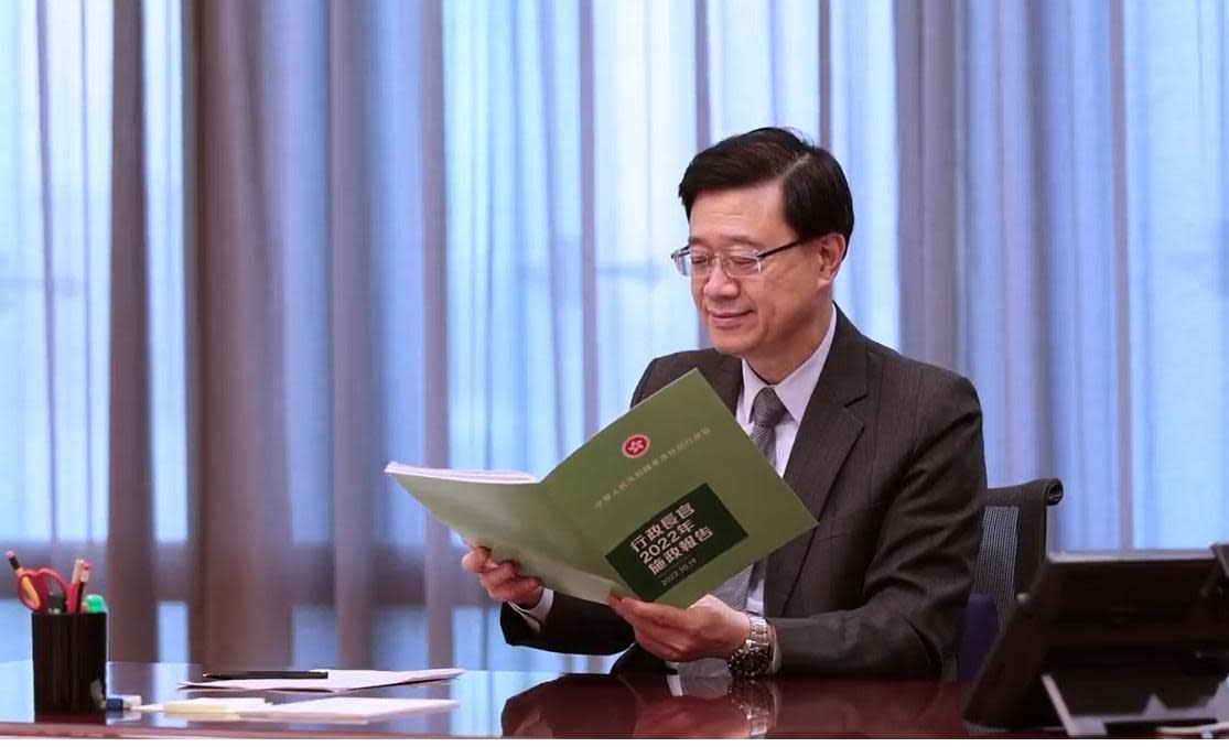 李家超手持《施政报告》阅读