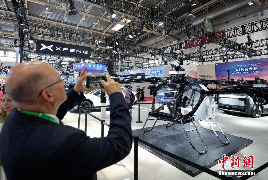 中新社记者 赵文宇 摄 7月16日，第三届中国国际供应链促进博览会在北京开幕。本届链博会设置先进制造链、智能汽车链、绿色农业链、清洁能源链、数字科技链、健康生活链等6大链条和供应链服务展区，共有75个国家和地区，651家企业和机构参展，境外参展商占比达35%。图为在智能汽车链展区，小鹏展台的飞行汽车吸引外国观众。