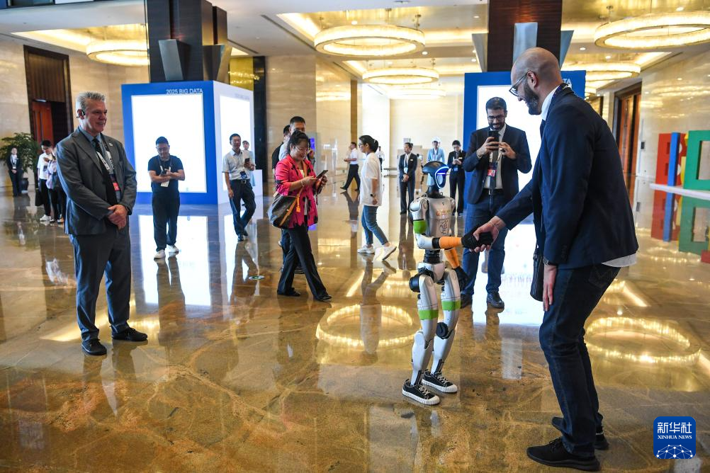 8月28日，参会人员在2025中国国际大数据产业博览会开幕式现场与一款机器人互动。 8月28日，2025中国国际大数据产业博览会在贵州省贵阳市开幕。本届数博会以“数聚产业动能 智启发展新篇”为主题，展现数据要素与人工智能技术融合创新的最新成果，推动数据资源的高效汇聚与价值释放，为产业升级和经济高质量发展注入强劲动力。 新华社记者 杨文斌 摄pagebreak