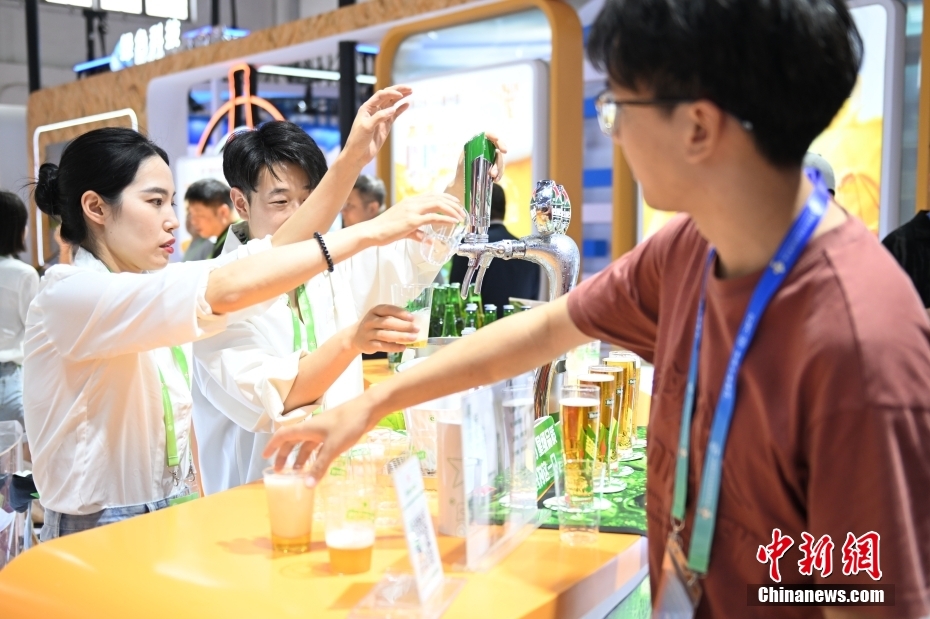 中新网记者 李骏 摄 图为观众在绿色农业链展区品尝啤酒。