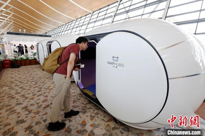 7月9日，旅客在浦东机场T2航站楼内了解休息舱。中新社记者 殷立勤 摄