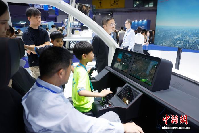 7月23日，孩子体验eVTOL(电动垂直起降)航空器模拟飞行。中新社记者 殷立勤 摄