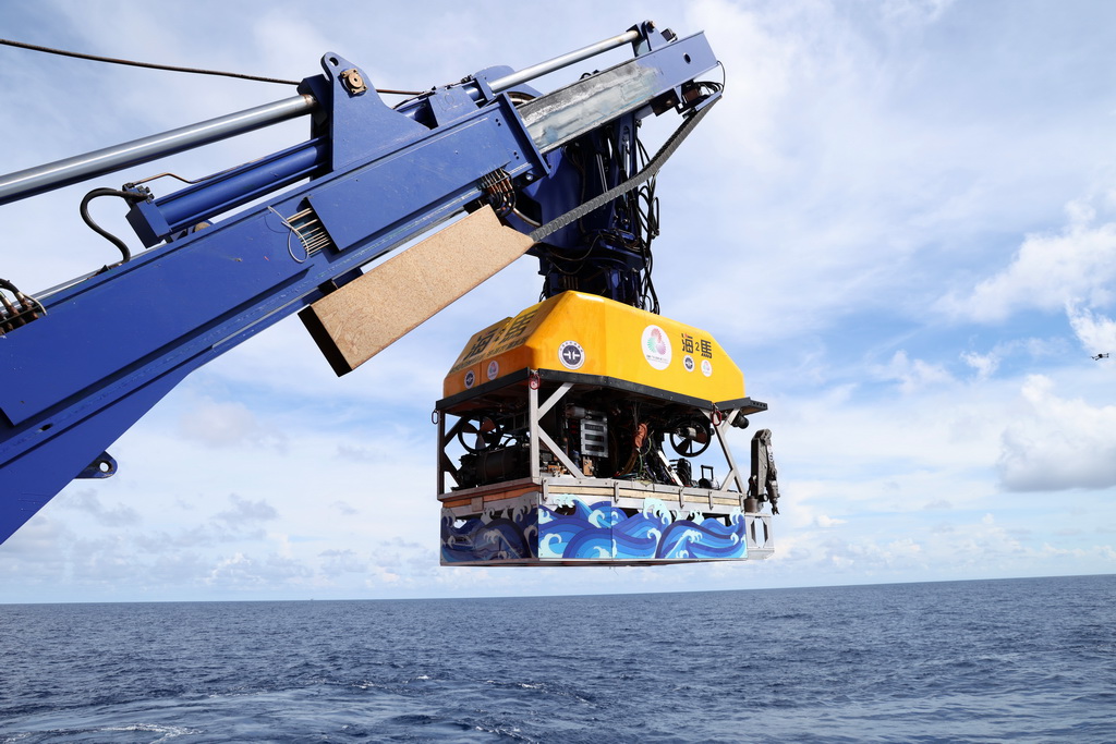 “海马”号深海遥控潜水器搭载着采火装置准备下水采集“源火”（9月18日摄）。 10月9日，第十五届全国运动会、全国第十二届残疾人运动会暨第九届特殊奥林匹克运动会火种采集仪式在广州举行。全运圣火“源火”来自南海1500多米深海底，通过引燃可燃冰的方式获取。 9月18日，在南海北部海域，我国自主研发的“海马”号深海遥控潜水器（ROV）搭载“可燃冰原位采集分解及引燃装置”下潜到1500多米深海底，科研人员远程操控采集可燃冰，并降压使其分解，产生的甲烷气体即为“源火”气源。随后，科考船甲板面的太阳能光伏装置发电并传输到海底，引燃气源获取“源火”。“海马”号携带燃烧的“源火”返回科考船甲板面后，科研人员将“源火”转移至“源火”盒，“源火”采集成功。新华社记者 卢汉欣 摄