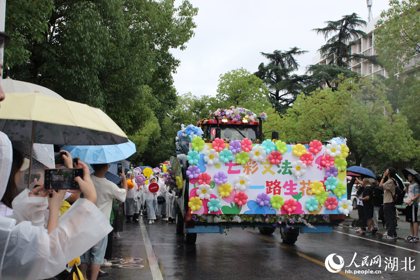 6月21日下午，华中农业大学举行2025年毕业巡游。16台现代农机装备组成的“钢铁长龙”在雨中浩荡启程，收割机、播种机、拖拉机等变身“花车”巡游校园，为毕业生铺就一条别开生面的青春征途。人民网记者 张沛摄影报道