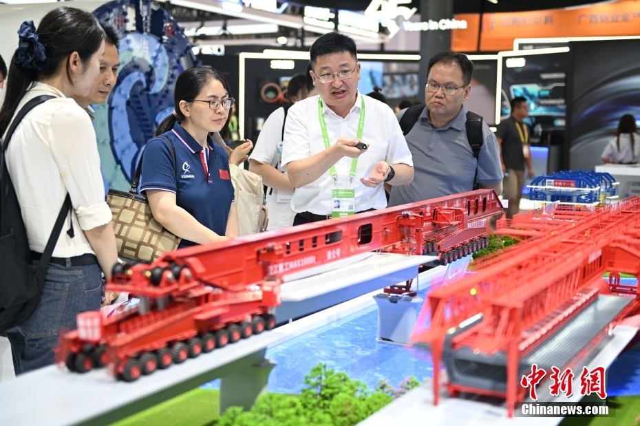 中新网记者 李骏 摄 图为先进制造链展区，工作人员在介绍“昆仑号”架桥机模型。