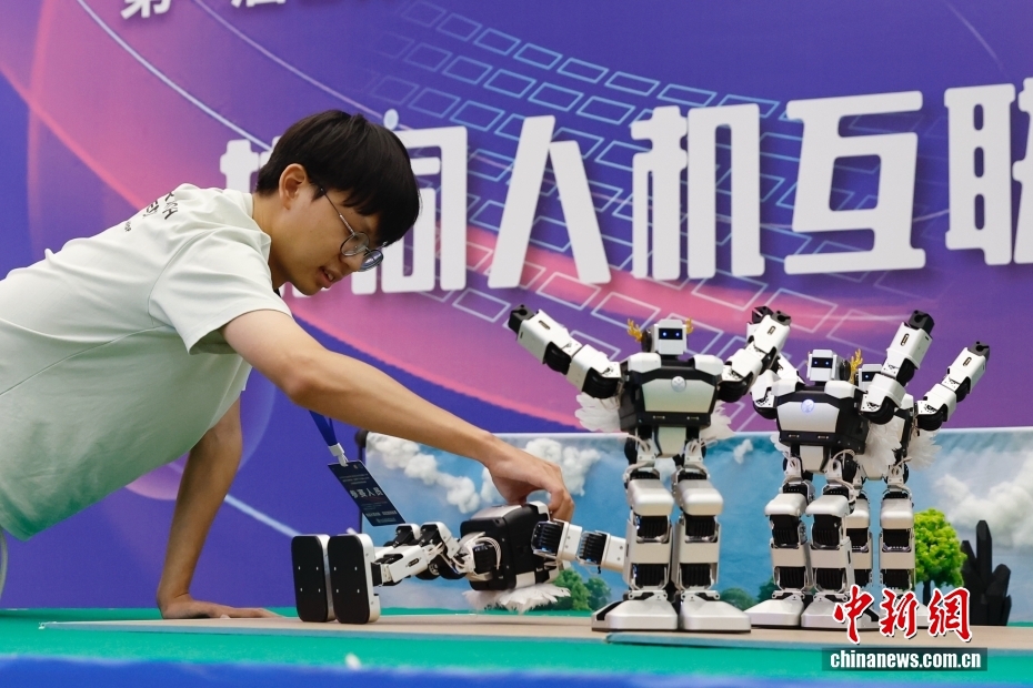 中新社记者 韩海丹 摄 8月2日，2025年华北五省（市、自治区）大学生机器人大赛舞蹈专项赛在北京信息科技大学举行。作为2025世界人形机器人运动会外围赛集体舞蹈赛的预选赛，本次大赛共有19所高校、32支队伍、176名师生参加。图为大学生扶起表演中倒下的机器人。