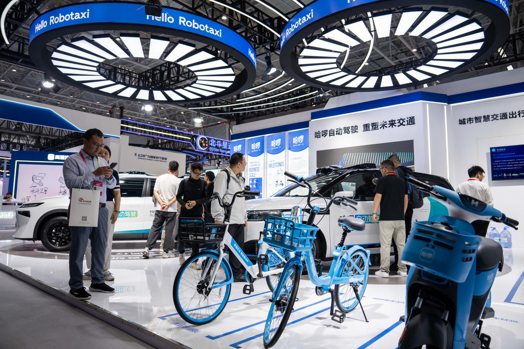 9月24日，在株洲国际会展中心，观众（左一）在拍摄配有北斗技术的共享单车。 9月24日，第四届北斗规模应用国际峰会在湖南株洲开幕，本届峰会以“同世界·共北斗——智联时空”为主题，除开幕式外，还设置1场高端主旨演讲、5场主题论坛、6场学术交流、1个场景示范展等活动，展示北斗规模应用与经济社会的深度融合。新华社记者 陈思汗 摄