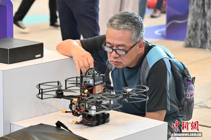 图为一名男士认真观看无人机设备。中新网记者 李志华 摄