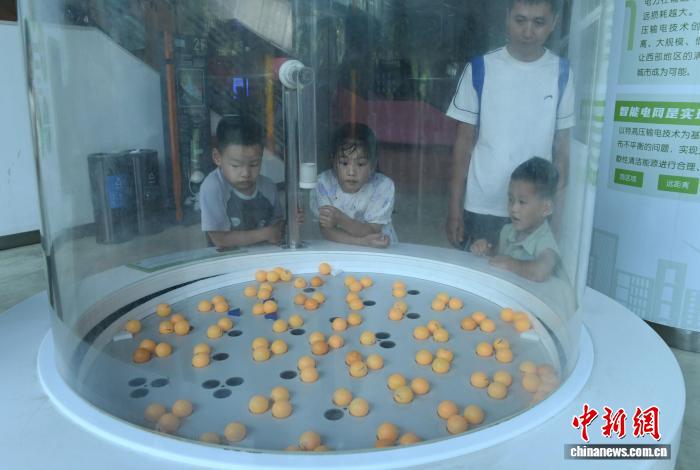 8月21日，正值暑假，重庆科技馆变身儿童乐园，吸引不少市民带着小孩前来参观、游玩，探索科学奥秘。图为小朋友们观察链式反应。中新社记者 周毅 摄