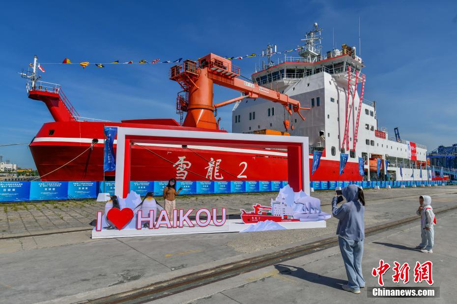 中新社记者 骆云飞 摄 6月2日，完成中国第41次南极考察任务的“雪龙2”号极地科学考察破冰船，停靠在海南省海口市秀英港码头，开启为期5天的公众开放日活动。公众可近距离参观实验室、驾驶室以及飞行平台等多个特色区域。“雪龙2”号是中国首艘自主建造的极地科学考察破冰船。图为民众与“雪龙2”号极地科学考察破冰船合影。