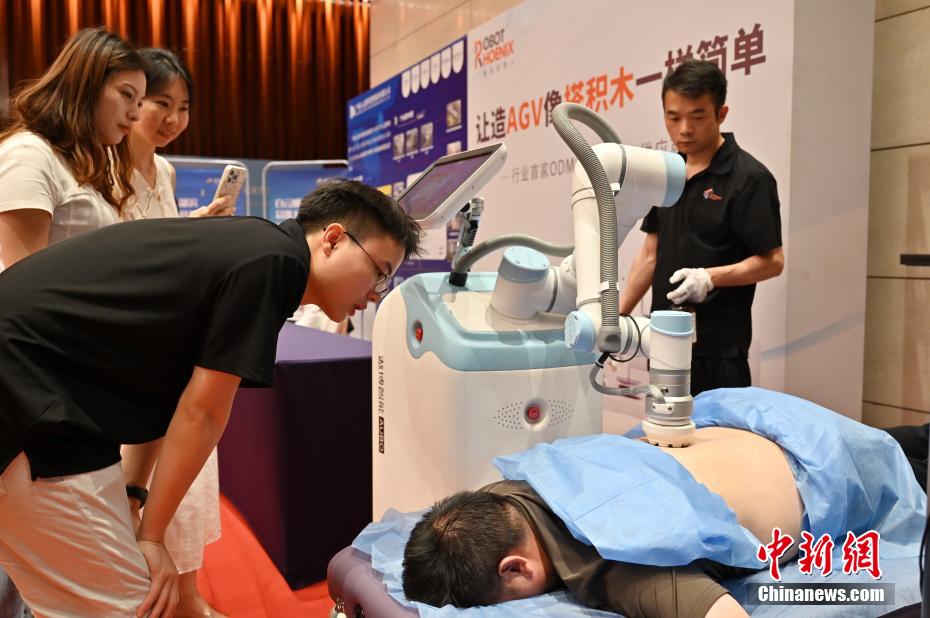 中新社记者 陈楚红 摄 5月21日，2025全球智能机器人发展大会在广东省广州白云国际会议中心开幕。大会以“遇见未来，拥抱智能”为主题，汇聚全球顶尖行业领袖、权威学者及创新企业代表，深入探讨人工智能在智能制造、工作生活、服务消费等领域的潜力与挑战。图为按摩机器人吸引参观者体验。