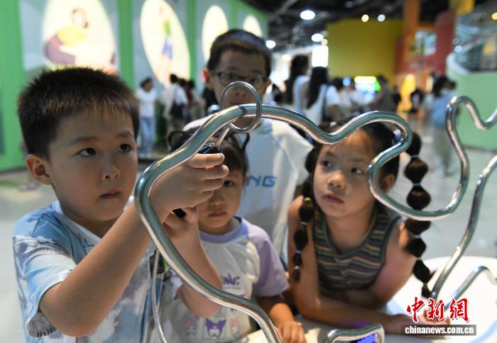 8月21日，正值暑假，重庆科技馆变身儿童乐园，吸引不少市民带着小孩前来参观、游玩，探索科学奥秘。图为小朋友体验一笔画。中新社记者 周毅 摄