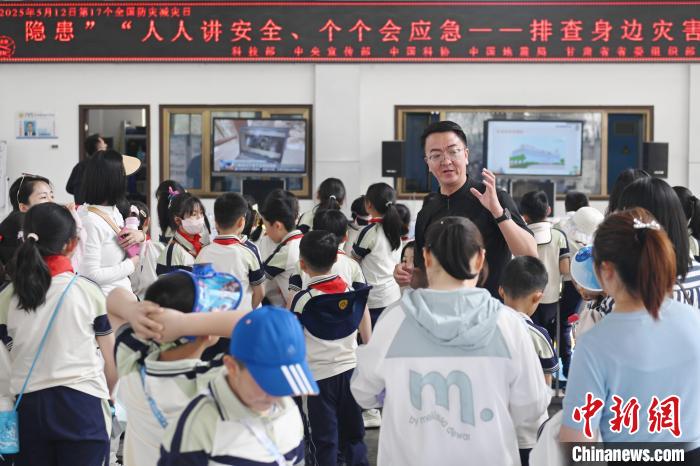 图为工作人员向参观学生讲述防灾减灾知识。中新社记者 李亚龙 摄