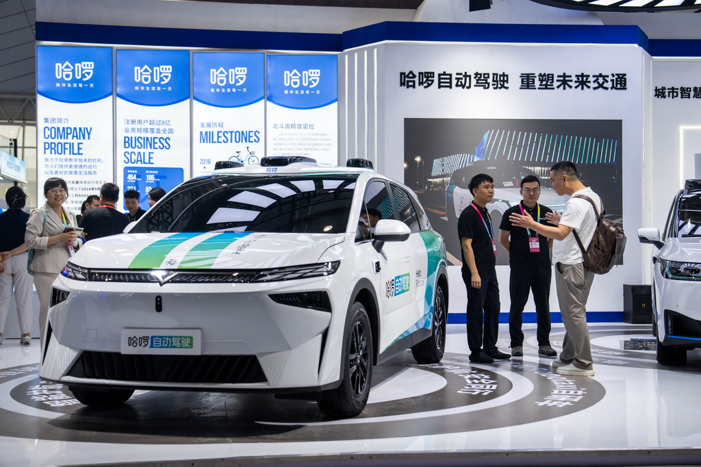 9月24日，在株洲国际会展中心，观众（右一）在了解一台配有北斗技术的自动驾驶汽车。 9月24日，第四届北斗规模应用国际峰会在湖南株洲开幕，本届峰会以“同世界·共北斗——智联时空”为主题，除开幕式外，还设置1场高端主旨演讲、5场主题论坛、6场学术交流、1个场景示范展等活动，展示北斗规模应用与经济社会的深度融合。新华社记者 陈思汗 摄